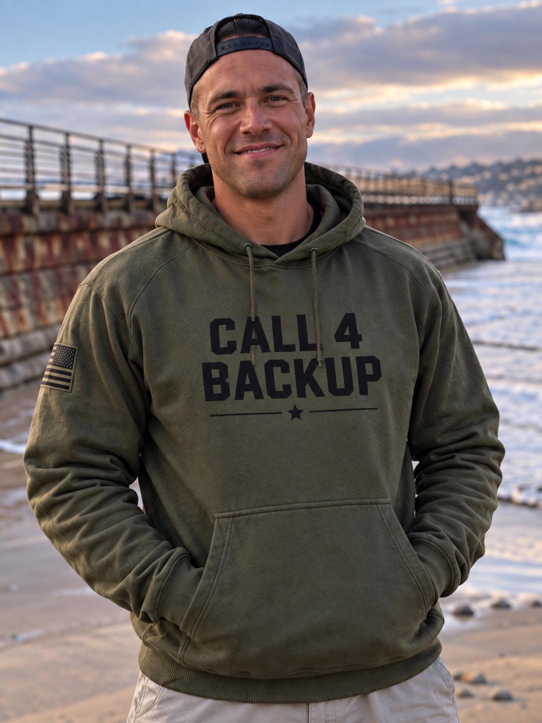 A supplied coastal portrait showing the Military Green Call 4 Backup hoodie.